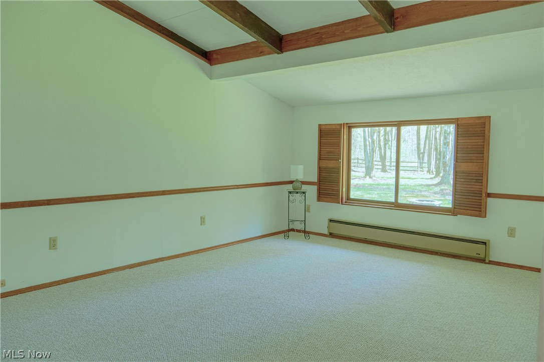 7172 Tessmer Road Williamsfield, OH 44093 - Photo 10 of 23 Carpeted spare room featuring lofted ceiling with beams and baseboard heating