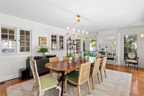 a dining room with furniture a rug and a potted plant