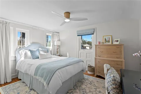 a bedroom with a bed and a table with wooden floor