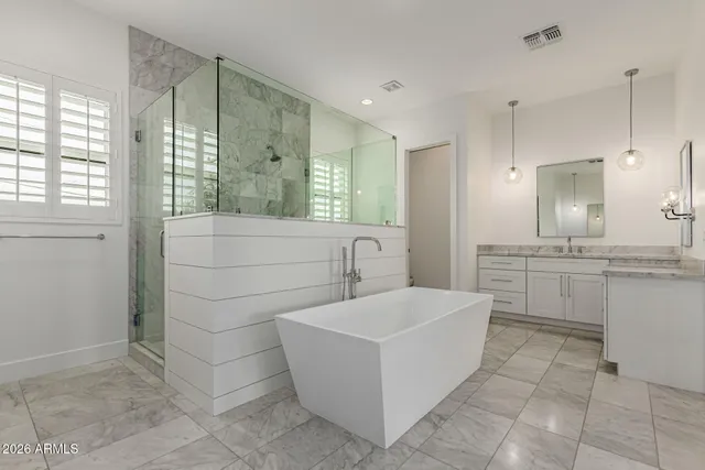 a white bath tub sitting in a bathroom and shower