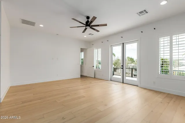 a view of a room with wooden floor and a ceiling fan