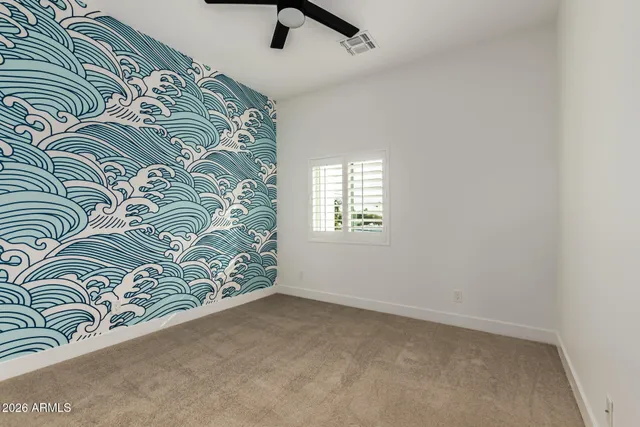 an empty room with a window and a fan