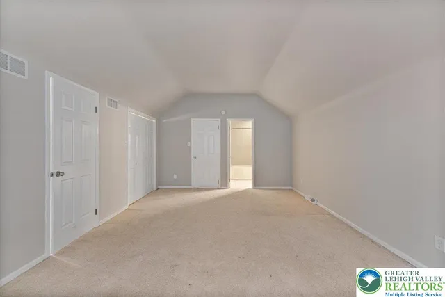 an empty room with closet and natural light