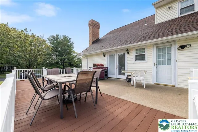 a view of a patio with dining table and chairs with wooden floor and fence