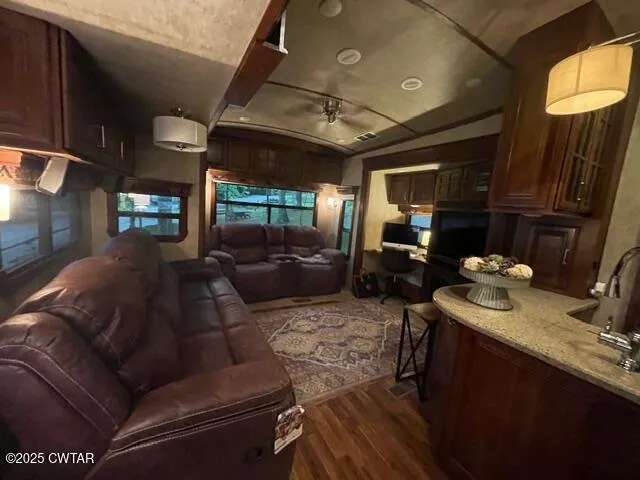 a living room with furniture a ceiling fan and a window