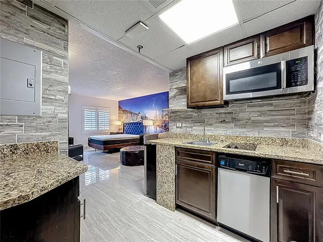 a kitchen with stainless steel appliances granite countertop a sink stove microwave and cabinets