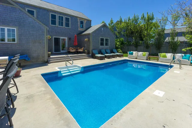 a swimming pool with outdoor seating and yard
