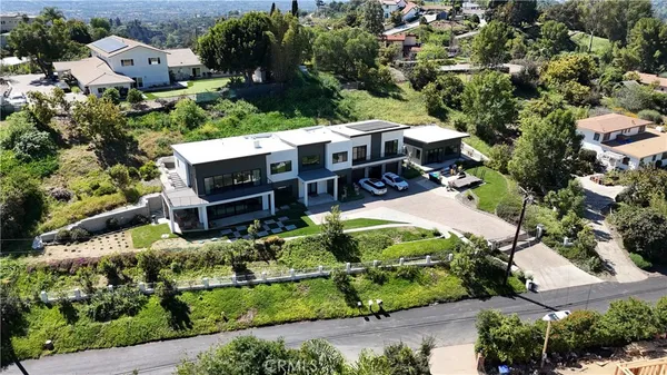 an aerial view of a houses with a lush green hillside