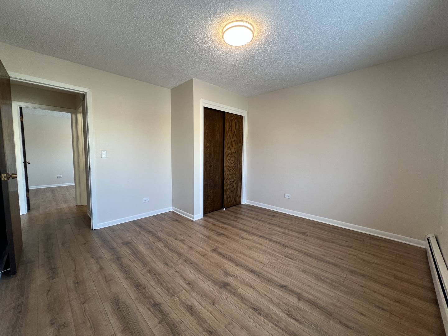 1279 Harding Avenue, Unit 3B Des Plaines, IL 60016 - Photo 11 of 15 an empty room with wooden floor and closet