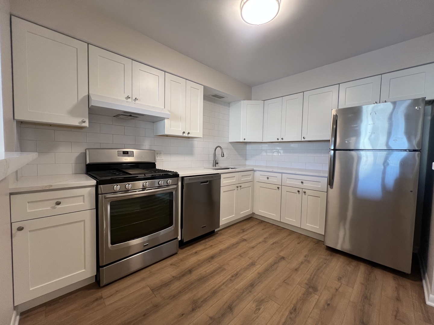 1279 Harding Avenue, Unit 3B Des Plaines, IL 60016 - Photo 3 of 15 a white kitchen with sink a refrigerator and white cabinets