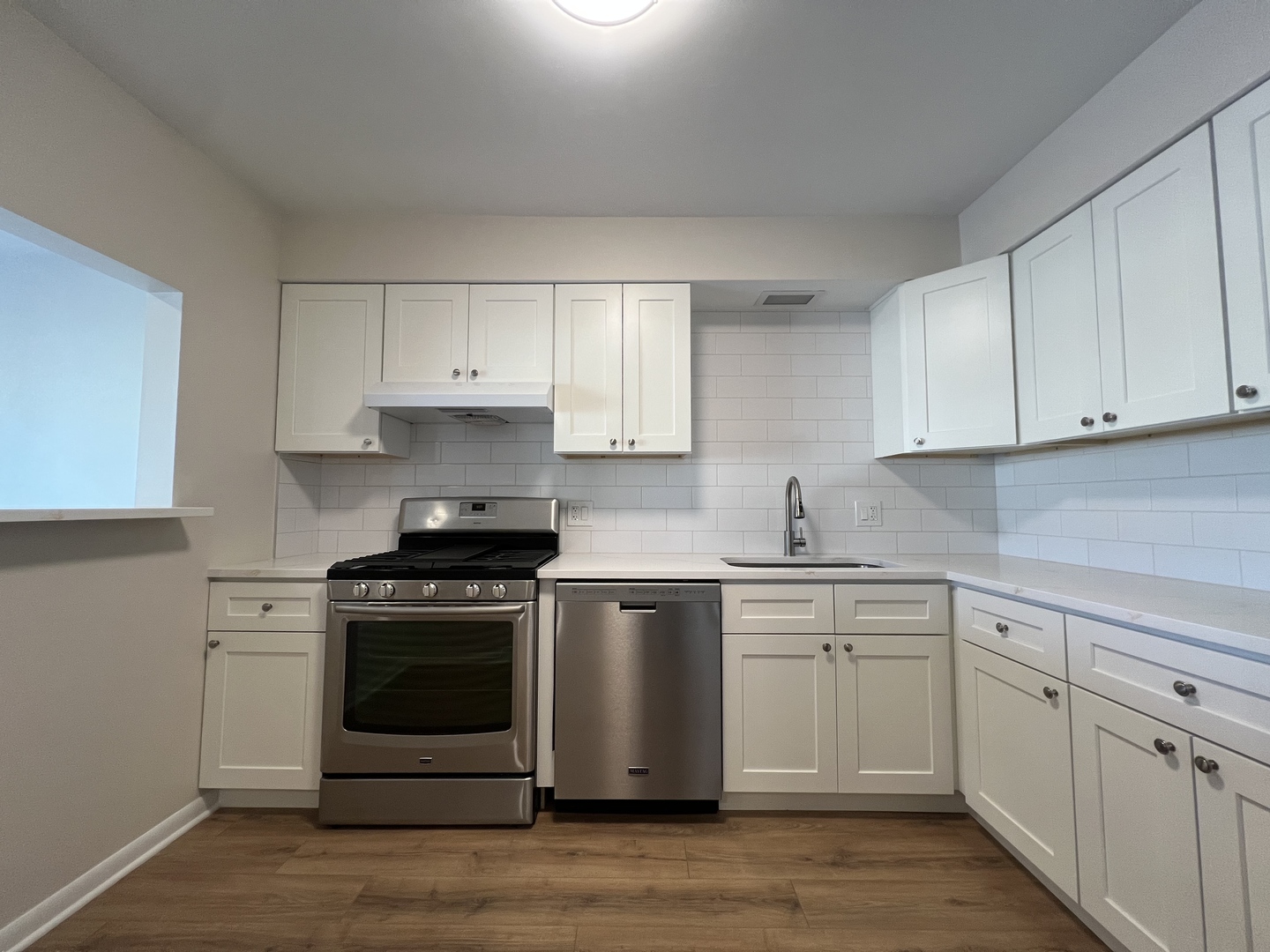1279 Harding Avenue, Unit 3B Des Plaines, IL 60016 - Photo 4 of 15 a white kitchen with granite countertop stainless steel appliances