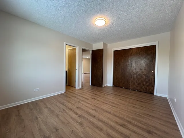 an empty room with wooden floor and closet