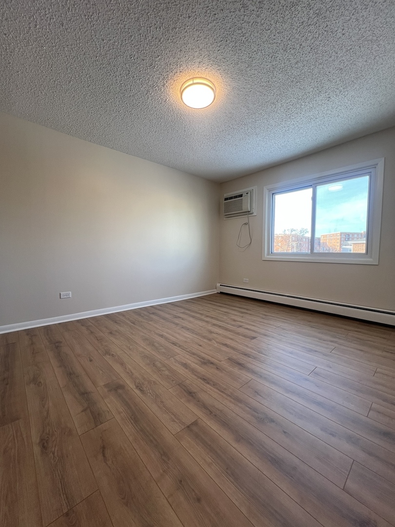 1279 Harding Avenue, Unit 3B Des Plaines, IL 60016 - Photo 10 of 15 an empty room with wooden floor and windows