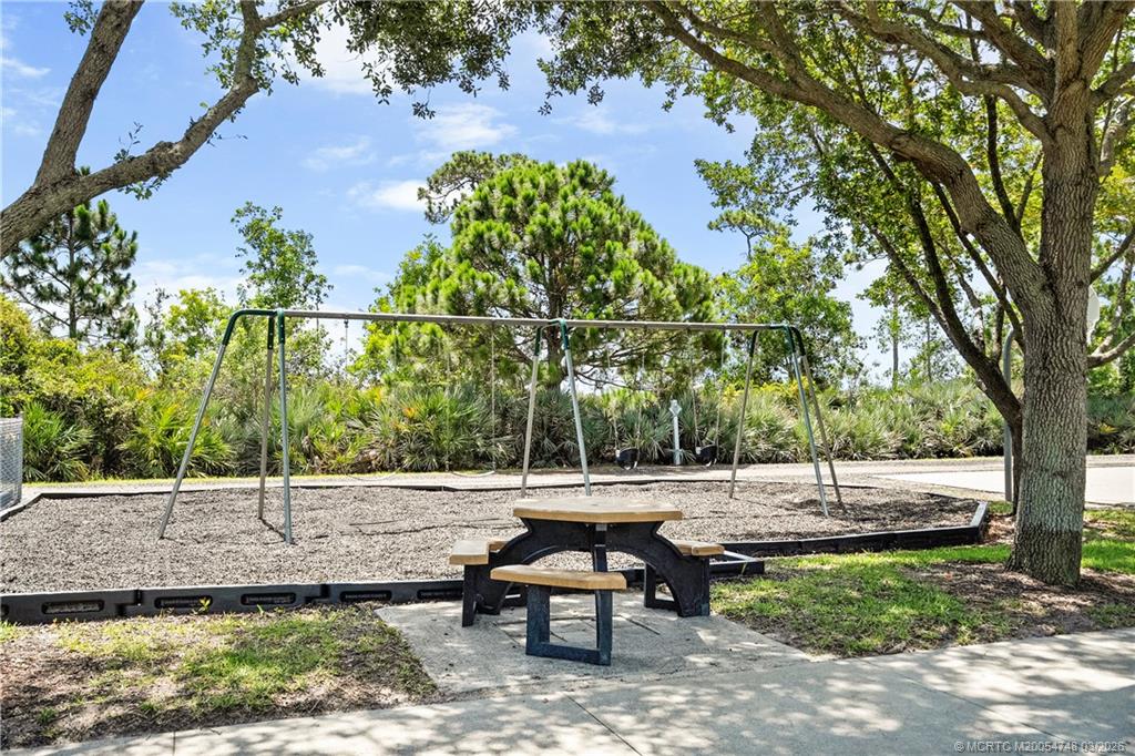 2119 Northwest Marsh Rabbit Lane Jensen Beach, FL 34957 - Photo 5 of 7 a view of a bench in a backyard