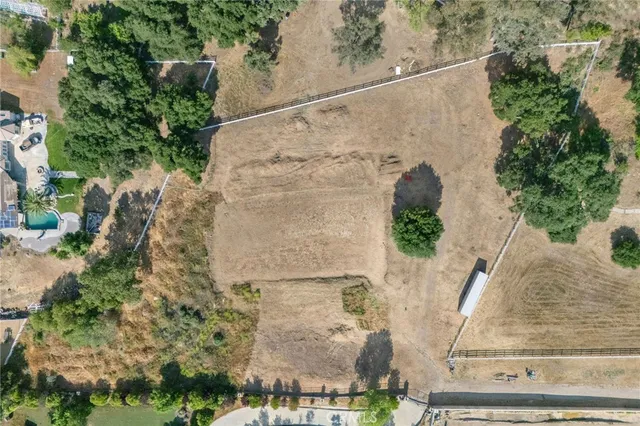 an aerial view of residential houses with outdoor space and trees