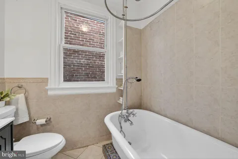 a bathroom with a white bath tub a toilet and a sink