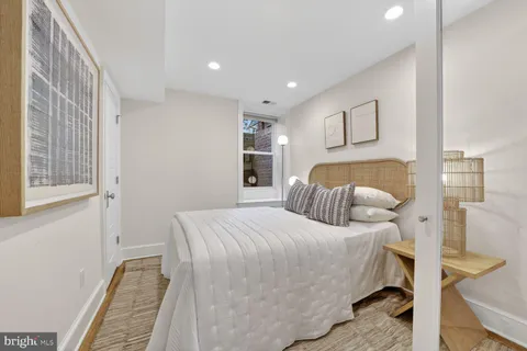 a bedroom with a bed and a painting on the wall