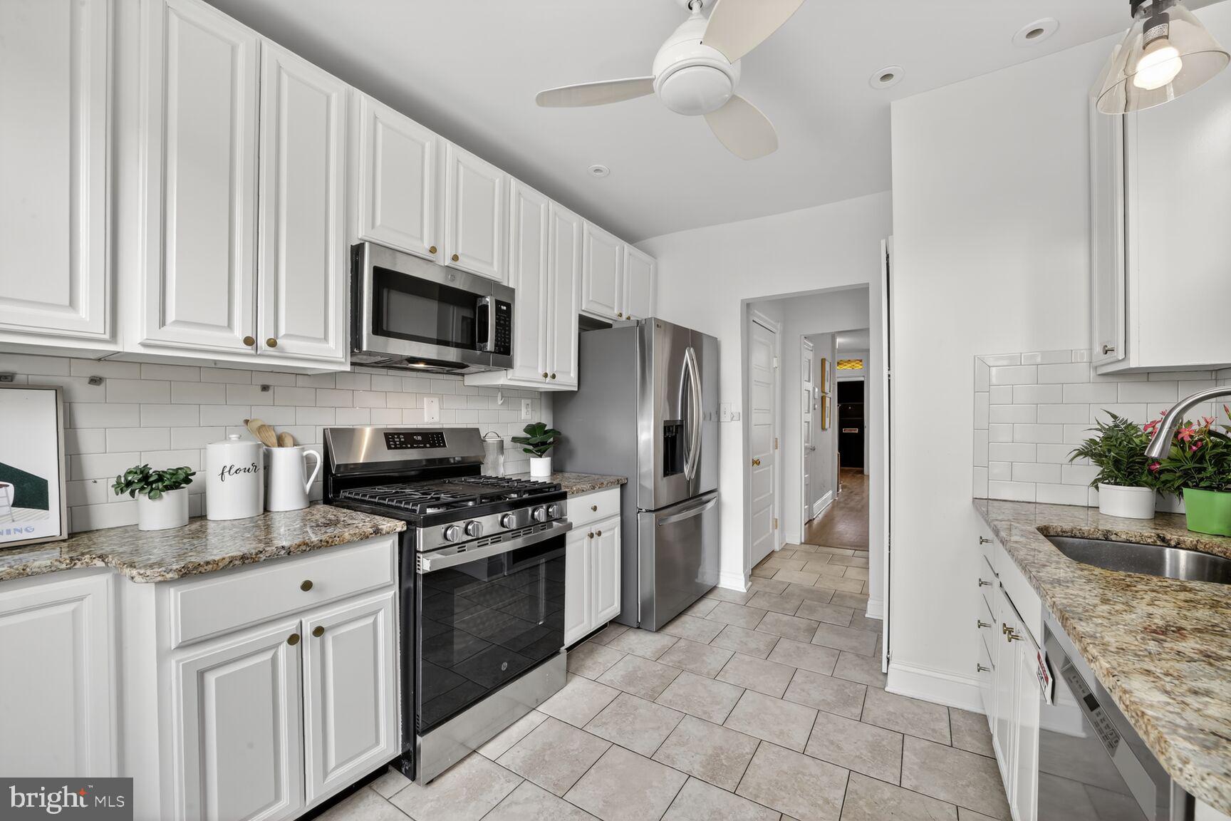 1612 V Street Northwest Washington, DC 20009 - Photo 7 of 29 a kitchen with stainless steel appliances granite countertop a stove a sink dishwasher a refrigerator and a microwave oven with white cabinets