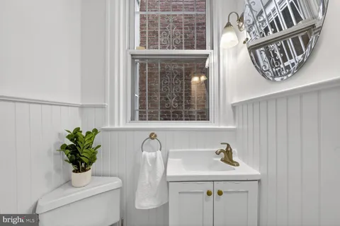 a bathroom with a sink a toilet and a window