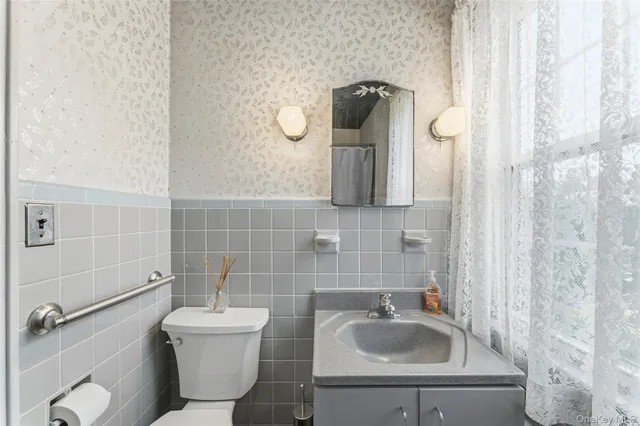 a bathroom with a toilet sink and mirror