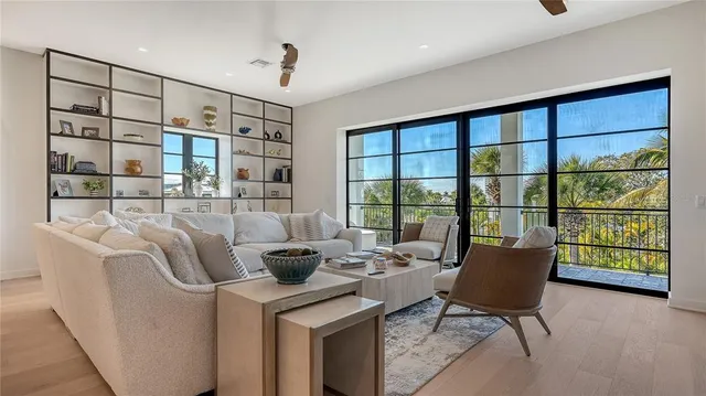 a living room with furniture potted plant and a large window