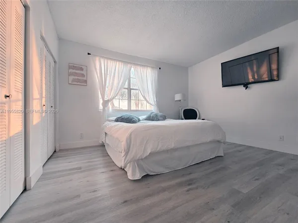 a bedroom with a bed and a flat screen tv