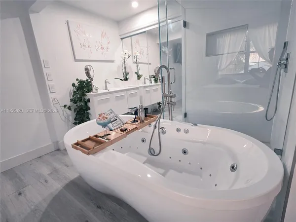 a bathroom with a tub sink and mirror