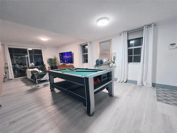 a room with furniture pool table and windows