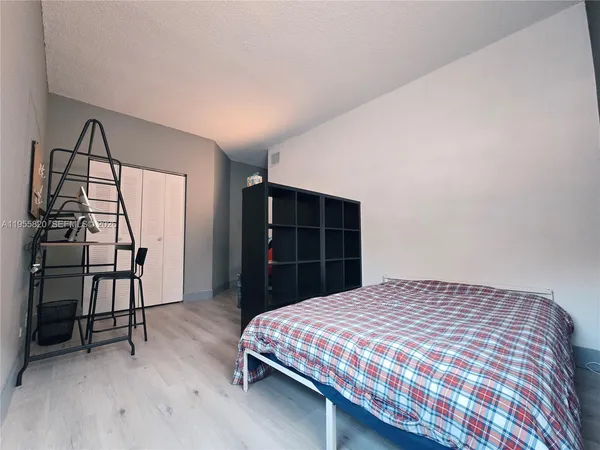 a bedroom with a bed a dresser and a window