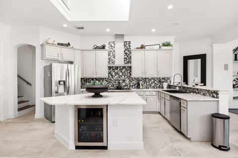 a kitchen with stainless steel appliances kitchen island granite countertop a refrigerator and a stove top oven