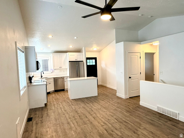 11895 Inauguration Road Draper, UT 84020 - Photo 5 of 13 Open-concept living area featuring wood-finish flooring, a modern kitchen with white cabinetry and stainless steel appliances, a center island, and a black ceiling fan