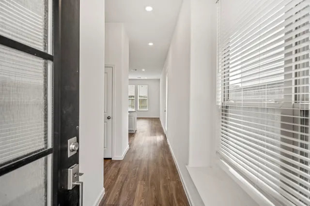 a view of a hallway with wooden floor and staircase