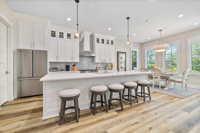 a kitchen with stainless steel appliances granite countertop a table chairs sink refrigerator and microwave