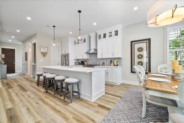 a large white kitchen with lots of furniture and appliances