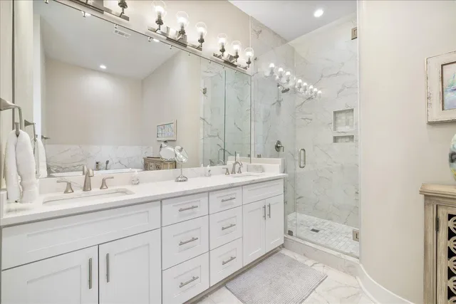 a bathroom with a double vanity sink mirror double and shower