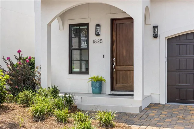 a front view of a house with potted plants