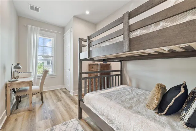 a bedroom with a bed and wooden floor