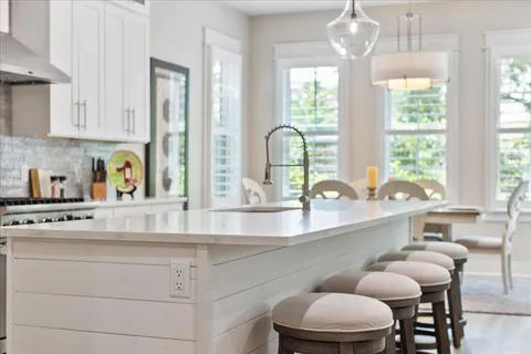 a kitchen with a table chairs sink and cabinets