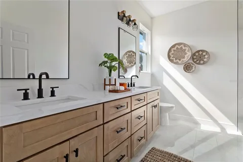 a bathroom with a granite countertop sink a vanity and a large mirror