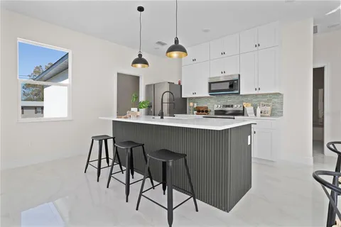 a kitchen with kitchen island granite countertop a sink a center island a counter and cabinets