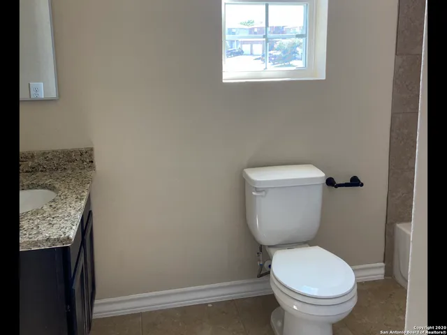 a white toilet sitting next to a window