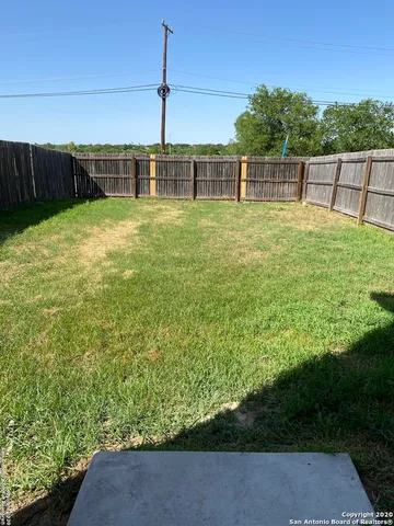 a view of a backyard with lawn chairs