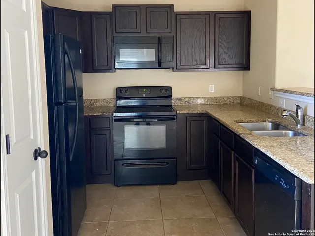 a kitchen with a sink stove and cabinets