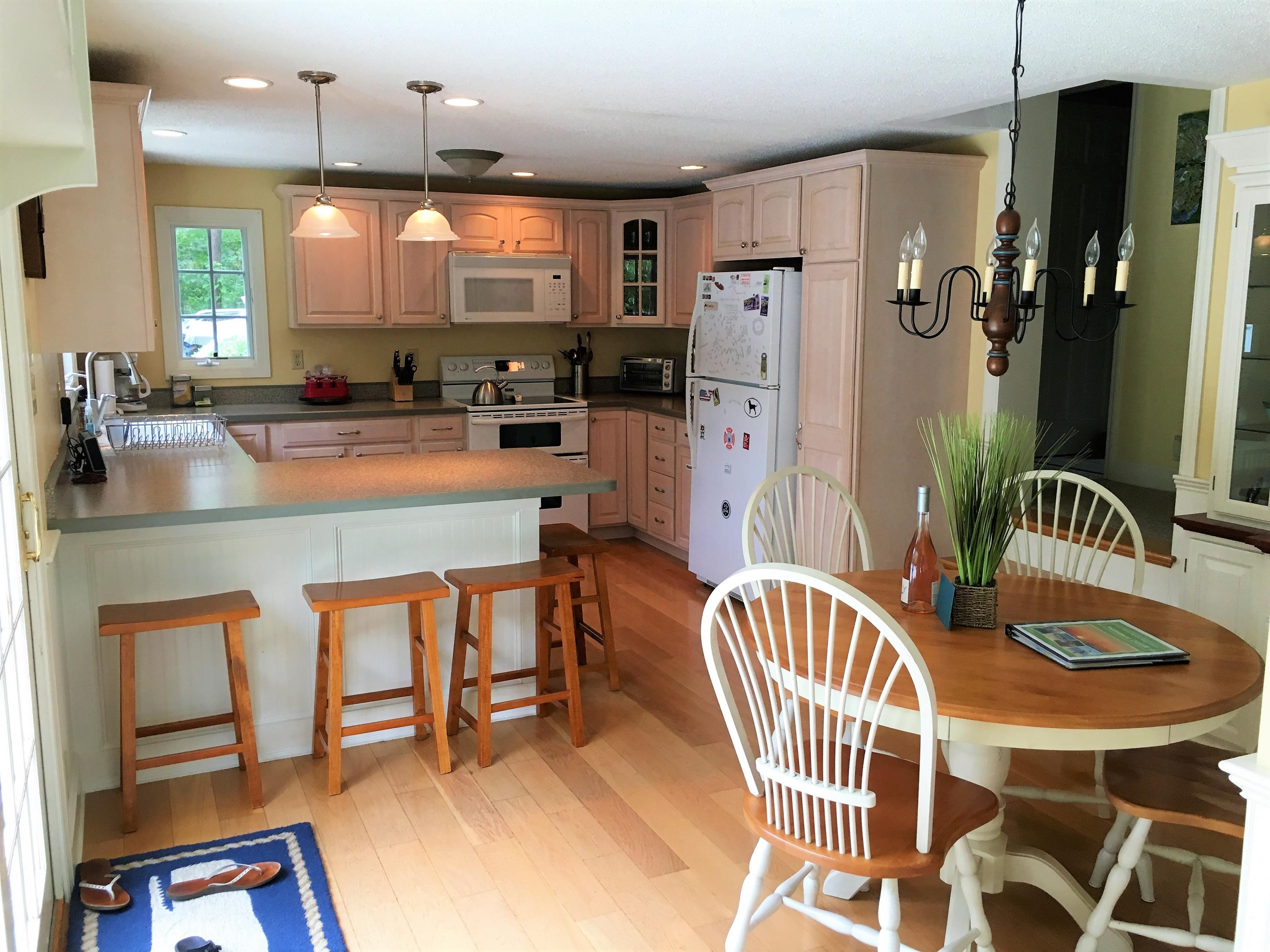 112 3rd Street North Edgartown, MA 02539 - Photo 7 of 15 a kitchen with stainless steel appliances granite countertop a table chairs and a refrigerator