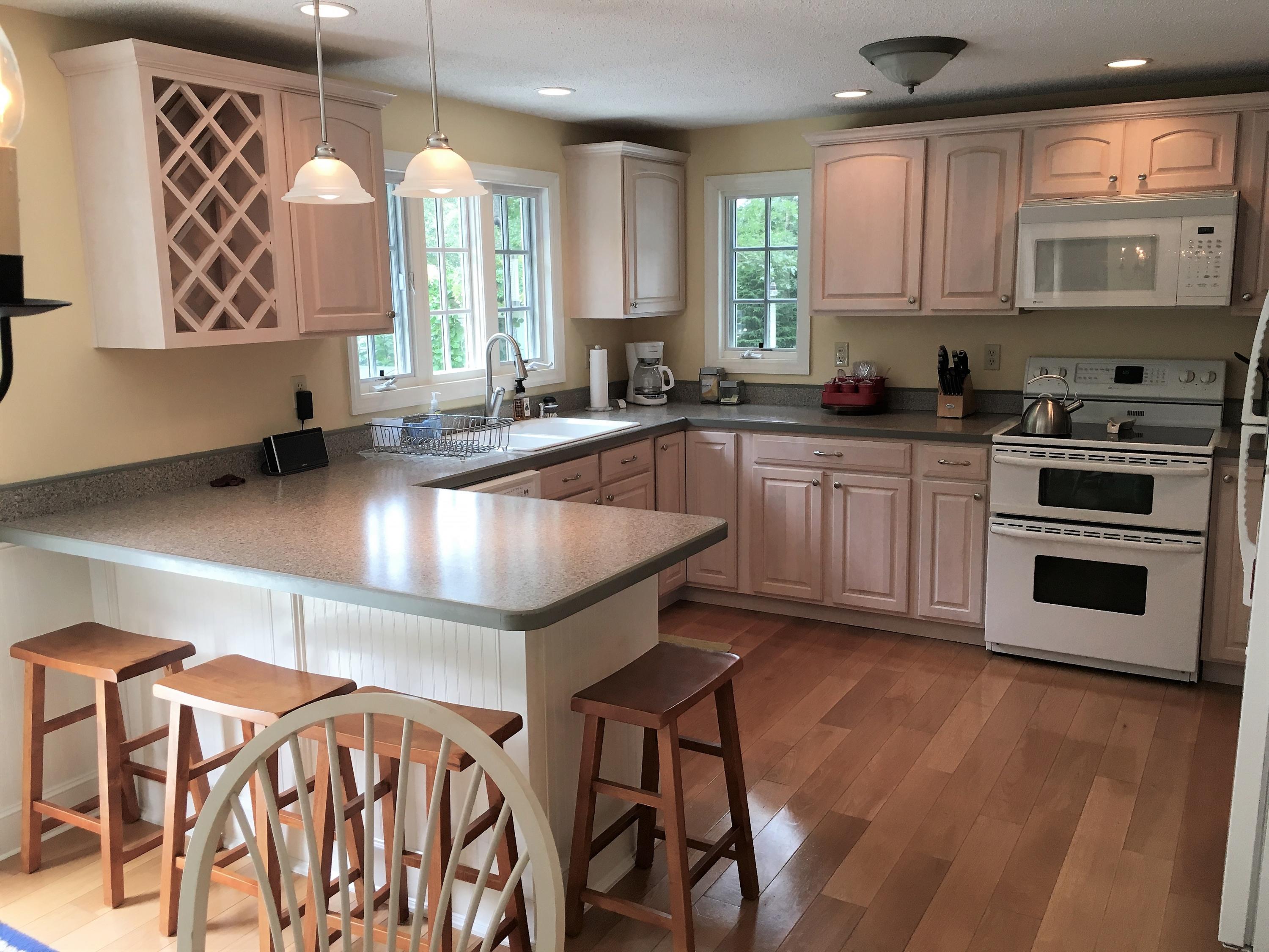 112 3rd Street North Edgartown, MA 02539 - Photo 8 of 15 a kitchen with stainless steel appliances granite countertop a stove a sink and a microwave