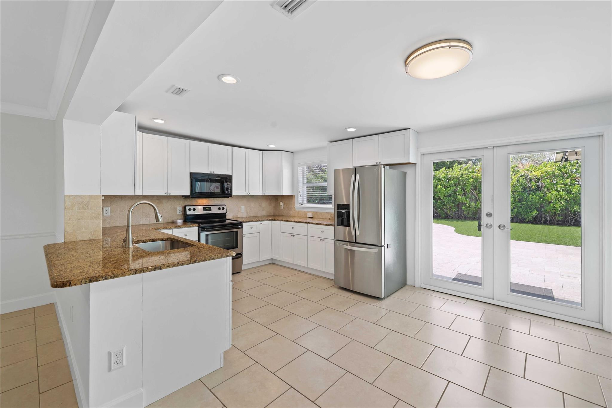 413 Philadelphia Drive Jupiter, FL 33458 - Photo 11 of 35 a kitchen with a refrigerator a stove cabinets and living room view