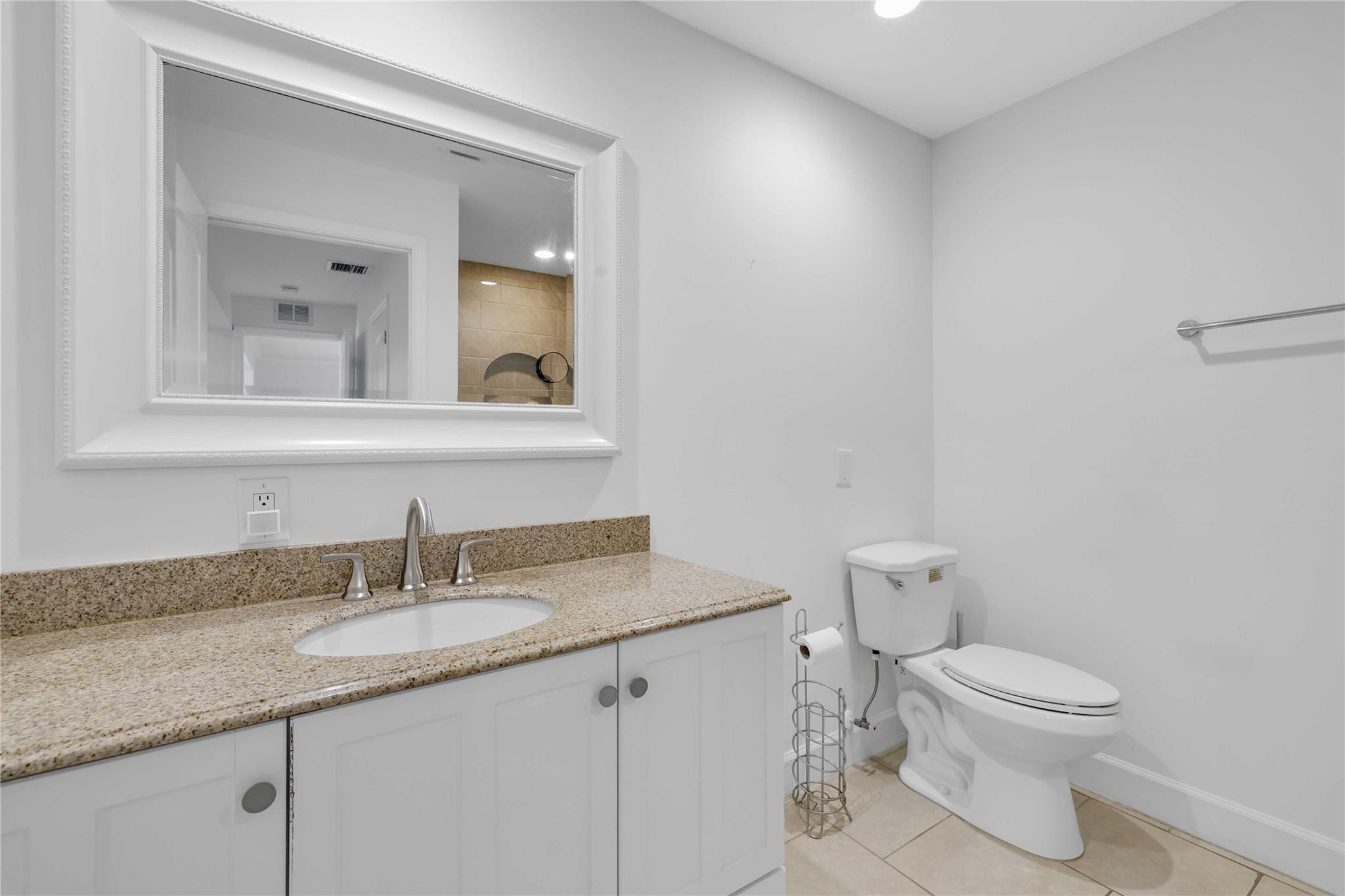 413 Philadelphia Drive Jupiter, FL 33458 - Photo 16 of 35 a bathroom with a granite countertop sink a toilet and a mirror