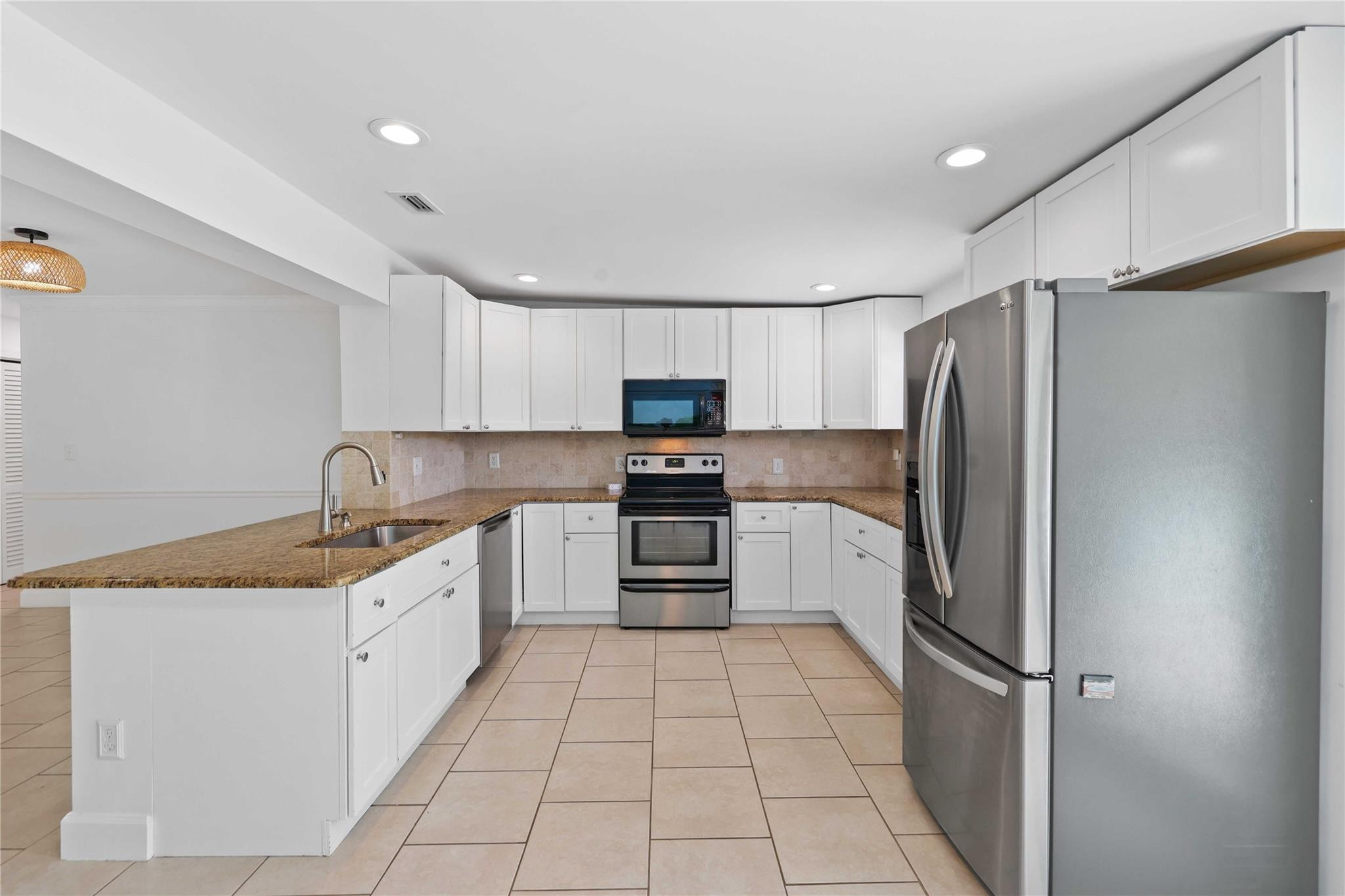 413 Philadelphia Drive Jupiter, FL 33458 - Photo 10 of 35 a kitchen with granite countertop a refrigerator and a sink
