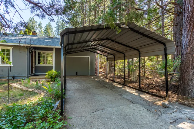 a view of a house with a large tree and wooden fence