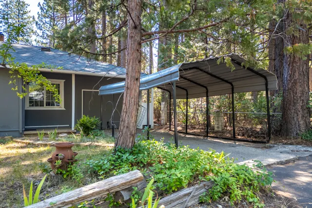 a view of a garden with a table and chairs under an umbrella
